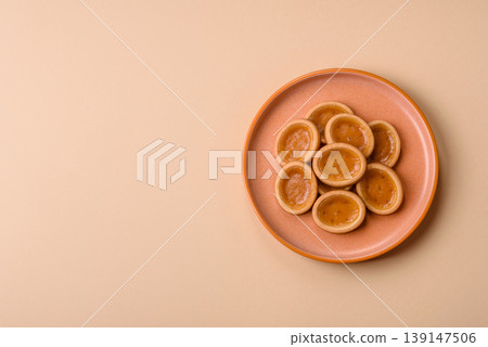 Round mini tartlets with citrus or peach jam and crumbly pastry. Mini citrus tarts Round mini tartlets with citrus or peach jam and crumbly pastry. Mini citrus tarts 139147506
