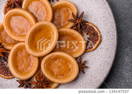 Round mini tartlets with citrus or peach jam and crumbly pastry. Mini citrus tarts 139147507
