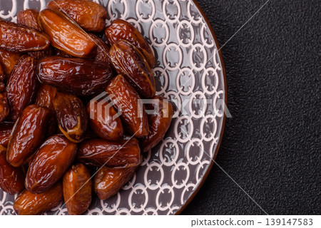 Dried dates on a ceramic plate for Ramadan or Iftar. Dates fruit as a background Dried dates on a ceramic plate for Ramadan or Iftar. Dates fruit as a background 139147583