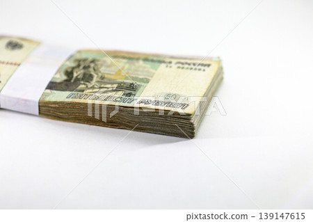 Many packs of Russian Ruble bills, stacks of banknotes, pile of cash, paper money. The concept of financial success, Investment and wealth. isolate on white background. Many packs of Russian Ruble bills, stacks of banknotes, pile of cash, paper money. The concept of financial success, Investment and wealth. isolate on white background. 139147615