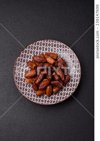 Dried dates on a ceramic plate for Ramadan or Iftar. Dates fruit as a background Dried dates on a ceramic plate for Ramadan or Iftar. Dates fruit as a background 139147699