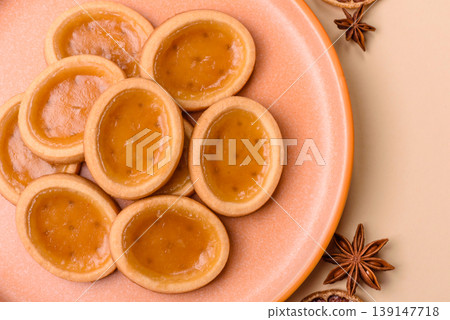 Round mini tartlets with citrus or peach jam and crumbly pastry. Mini citrus tarts Round mini tartlets with citrus or peach jam and crumbly pastry. Mini citrus tarts 139147718