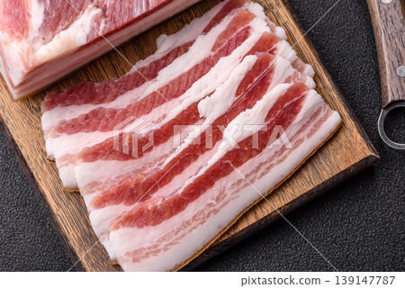Raw fresh bacon slices with layers of meat or prosciutto prepared for frying. Raw bacon Raw fresh bacon slices with layers of meat or prosciutto prepared for frying. Raw bacon 139147787
