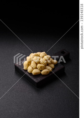 Raw homemade potato gnocchi, made with salt and spices, ready for lunch. Raw gnocchi Raw homemade potato gnocchi, made with salt and spices, ready for lunch. Raw gnocchi 139148318