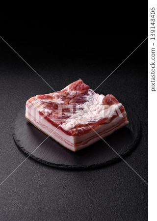 Raw fresh bacon slices with layers of meat or prosciutto prepared for frying. Raw bacon Raw fresh bacon slices with layers of meat or prosciutto prepared for frying. Raw bacon 139148406