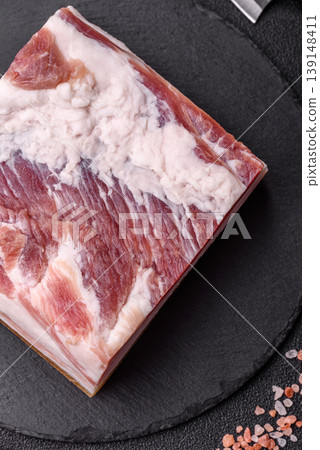Raw fresh bacon slices with layers of meat or prosciutto prepared for frying. Raw bacon Raw fresh bacon slices with layers of meat or prosciutto prepared for frying. Raw bacon 139148411