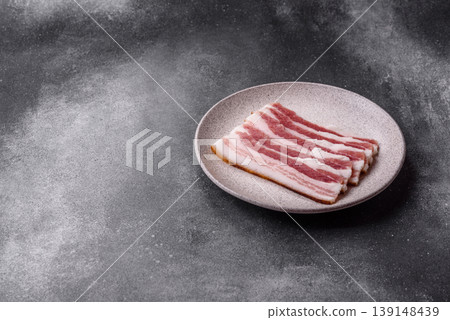 Raw fresh bacon slices with layers of meat or prosciutto prepared for frying. Raw bacon Raw fresh bacon slices with layers of meat or prosciutto prepared for frying. Raw bacon 139148439