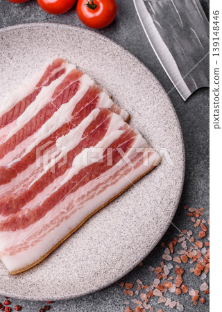 Raw fresh bacon slices with layers of meat or prosciutto prepared for frying. Raw bacon Raw fresh bacon slices with layers of meat or prosciutto prepared for frying. Raw bacon 139148446