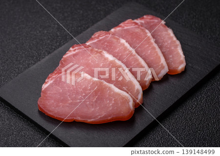 Smoked or dry cured meat slices, pork or ham with salt and spices. Smoked meat slices Smoked or dry cured meat slices, pork or ham with salt and spices. Smoked meat slices 139148499