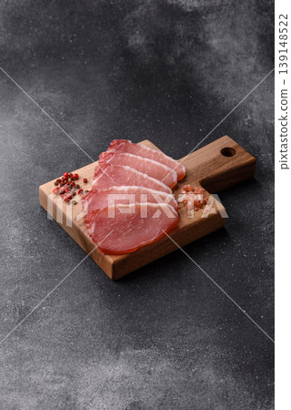 Smoked or dry cured meat slices, pork or ham with salt and spices. Smoked meat slices Smoked or dry cured meat slices, pork or ham with salt and spices. Smoked meat slices 139148522