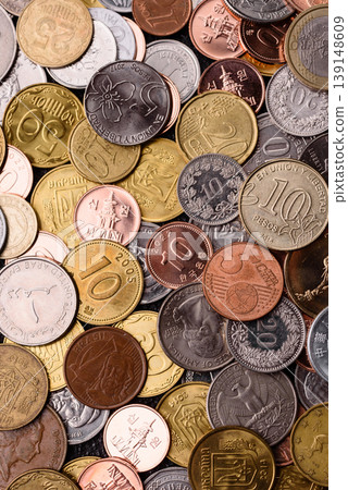 A background of silver, gold, and copper coins of various denominations. Metal coins 139148609