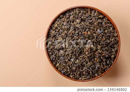 Granules of dried organic Chinese green tea with herbal additives. Dry green tea Granules of dried organic Chinese green tea with herbal additives. Dry green tea 139148802