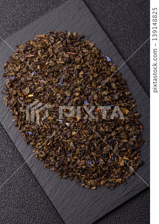 Granules of dried organic Chinese green tea with herbal additives. Dry green tea Granules of dried organic Chinese green tea with herbal additives. Dry green tea 139148825