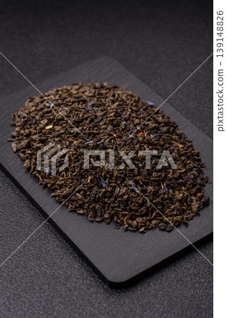 Granules of dried organic Chinese green tea with herbal additives. Dry green tea Granules of dried organic Chinese green tea with herbal additives. Dry green tea 139148826
