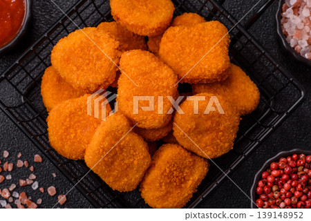 Fried chicken nuggets with sauce, salt, and spices, fast food, unhealthy food. Chicken nuggets Fried chicken nuggets with sauce, salt, and spices, fast food, unhealthy food. Chicken nuggets 139148952