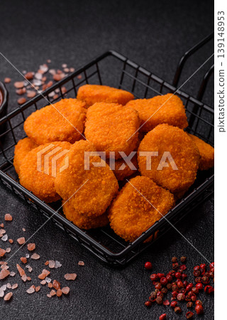 Fried chicken nuggets with sauce, salt, and spices, fast food, unhealthy food. Chicken nuggets Fried chicken nuggets with sauce, salt, and spices, fast food, unhealthy food. Chicken nuggets 139148953