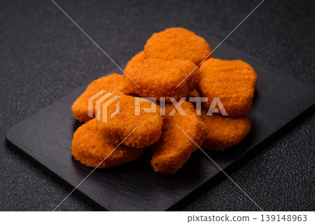 Fried chicken nuggets with sauce, salt, and spices, fast food, unhealthy food. Chicken nuggets Fried chicken nuggets with sauce, salt, and spices, fast food, unhealthy food. Chicken nuggets 139148963