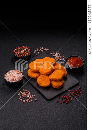 Fried chicken nuggets with sauce, salt, and spices, fast food, unhealthy food. Chicken nuggets Fried chicken nuggets with sauce, salt, and spices, fast food, unhealthy food. Chicken nuggets 139148971