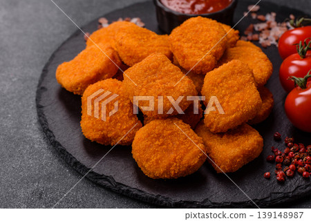 Fried chicken nuggets with sauce, salt, and spices, fast food, unhealthy food. Chicken nuggets Fried chicken nuggets with sauce, salt, and spices, fast food, unhealthy food. Chicken nuggets 139148987