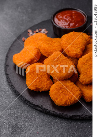 Fried chicken nuggets with sauce, salt, and spices, fast food, unhealthy food. Chicken nuggets Fried chicken nuggets with sauce, salt, and spices, fast food, unhealthy food. Chicken nuggets 139148989