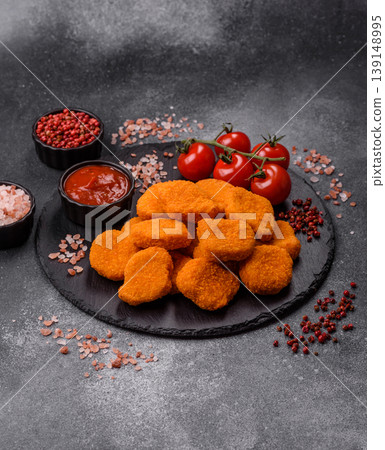 Fried chicken nuggets with sauce, salt, and spices, fast food, unhealthy food. Chicken nuggets Fried chicken nuggets with sauce, salt, and spices, fast food, unhealthy food. Chicken nuggets 139148995