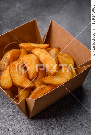 Potato wedges baked with garlic, herbs, and spices for lunch. Potato wedges Potato wedges baked with garlic, herbs, and spices for lunch. Potato wedges 139149003