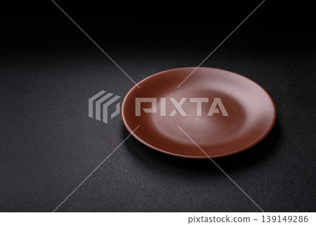 An empty ceramic round plate, kitchen utensils for a dinner table. An empty plate An empty ceramic round plate, kitchen utensils for a dinner table. An empty plate 139149286