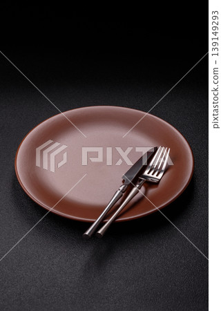 An empty ceramic round plate, kitchen utensils for a dinner table. An empty plate An empty ceramic round plate, kitchen utensils for a dinner table. An empty plate 139149293