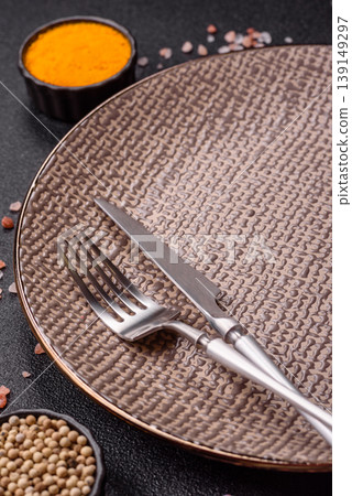 An empty ceramic round plate, kitchen utensils for a dinner table. An empty plate An empty ceramic round plate, kitchen utensils for a dinner table. An empty plate 139149297