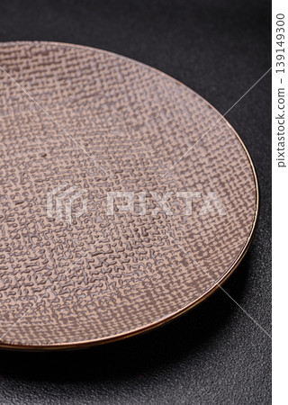 An empty ceramic round plate, kitchen utensils for a dinner table. An empty plate An empty ceramic round plate, kitchen utensils for a dinner table. An empty plate 139149300