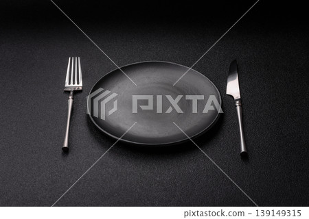 An empty ceramic round plate, kitchen utensils for a dinner table. An empty plate An empty ceramic round plate, kitchen utensils for a dinner table. An empty plate 139149315
