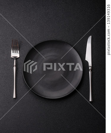 An empty ceramic round plate, kitchen utensils for a dinner table. An empty plate An empty ceramic round plate, kitchen utensils for a dinner table. An empty plate 139149316