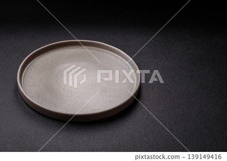 An empty ceramic round plate, kitchen utensils for a dinner table. An empty plate An empty ceramic round plate, kitchen utensils for a dinner table. An empty plate 139149416