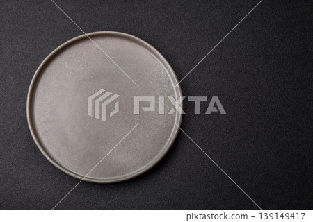 An empty ceramic round plate, kitchen utensils for a dinner table. An empty plate An empty ceramic round plate, kitchen utensils for a dinner table. An empty plate 139149417