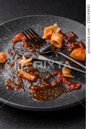 A dirty plate after a meal with leftover pasta and tomato sauce, cleaning. An empty dirty plate 139149491