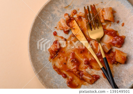 A dirty plate after a meal with leftover pasta and tomato sauce, cleaning. An empty dirty plate A dirty plate after a meal with leftover pasta and tomato sauce, cleaning. An empty dirty plate 139149501