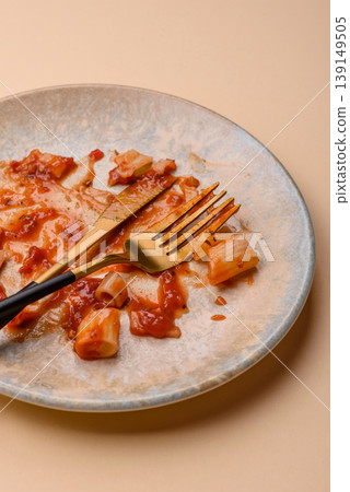 A dirty plate after a meal with leftover pasta and tomato sauce, cleaning. An empty dirty plate A dirty plate after a meal with leftover pasta and tomato sauce, cleaning. An empty dirty plate 139149505