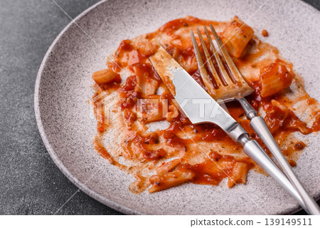 A dirty plate after a meal with leftover pasta and tomato sauce, cleaning. An empty dirty plate A dirty plate after a meal with leftover pasta and tomato sauce, cleaning. An empty dirty plate 139149511