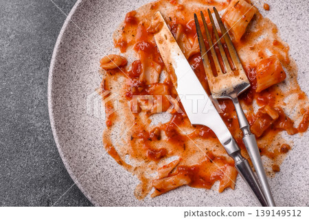 A dirty plate after a meal with leftover pasta and tomato sauce, cleaning. An empty dirty plate A dirty plate after a meal with leftover pasta and tomato sauce, cleaning. An empty dirty plate 139149512