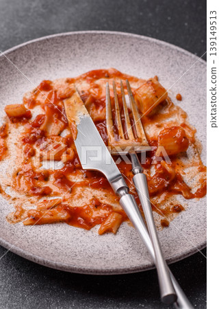 A dirty plate after a meal with leftover pasta and tomato sauce, cleaning. An empty dirty plate A dirty plate after a meal with leftover pasta and tomato sauce, cleaning. An empty dirty plate 139149513
