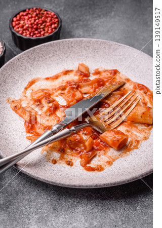 A dirty plate after a meal with leftover pasta and tomato sauce, cleaning. An empty dirty plate 139149517