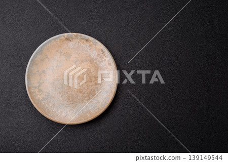An empty ceramic round plate, kitchen utensils for a dinner table. An empty plate An empty ceramic round plate, kitchen utensils for a dinner table. An empty plate 139149544