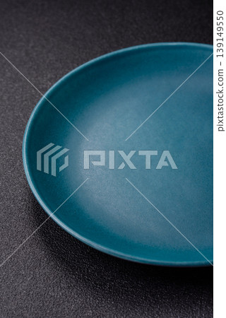 An empty ceramic round plate, kitchen utensils for a dinner table. An empty plate An empty ceramic round plate, kitchen utensils for a dinner table. An empty plate 139149550