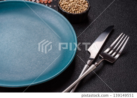 An empty ceramic round plate, kitchen utensils for a dinner table. An empty plate An empty ceramic round plate, kitchen utensils for a dinner table. An empty plate 139149551