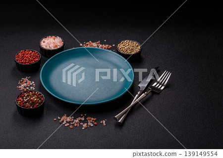An empty ceramic round plate, kitchen utensils for a dinner table. An empty plate 139149554