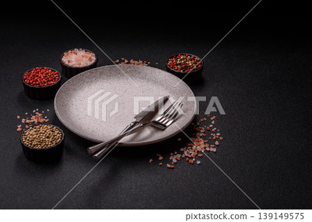 An empty ceramic round plate, kitchen utensils for a dinner table. An empty plate An empty ceramic round plate, kitchen utensils for a dinner table. An empty plate 139149575