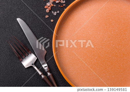 An empty ceramic round plate, kitchen utensils for a dinner table. An empty plate An empty ceramic round plate, kitchen utensils for a dinner table. An empty plate 139149581