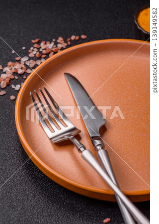 An empty ceramic round plate, kitchen utensils for a dinner table. An empty plate An empty ceramic round plate, kitchen utensils for a dinner table. An empty plate 139149582