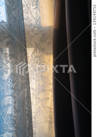 Lace curtains bathed in the morning sun 139149752
