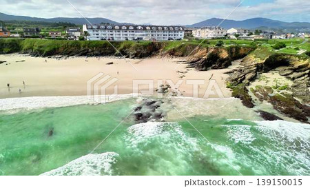 Enjoy a beautiful beach from an aerial view, with waves and a hotel Enjoy a beautiful beach from an aerial view, with waves and a hotel 139150015